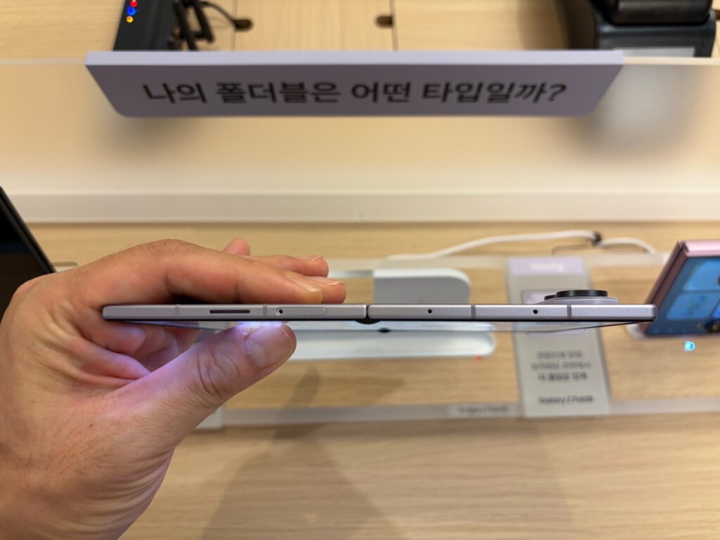 백화점 팝업 스토어에서 펼친 갤럭시 Z 폴드 8의 두께를 직접 살펴보는 모습